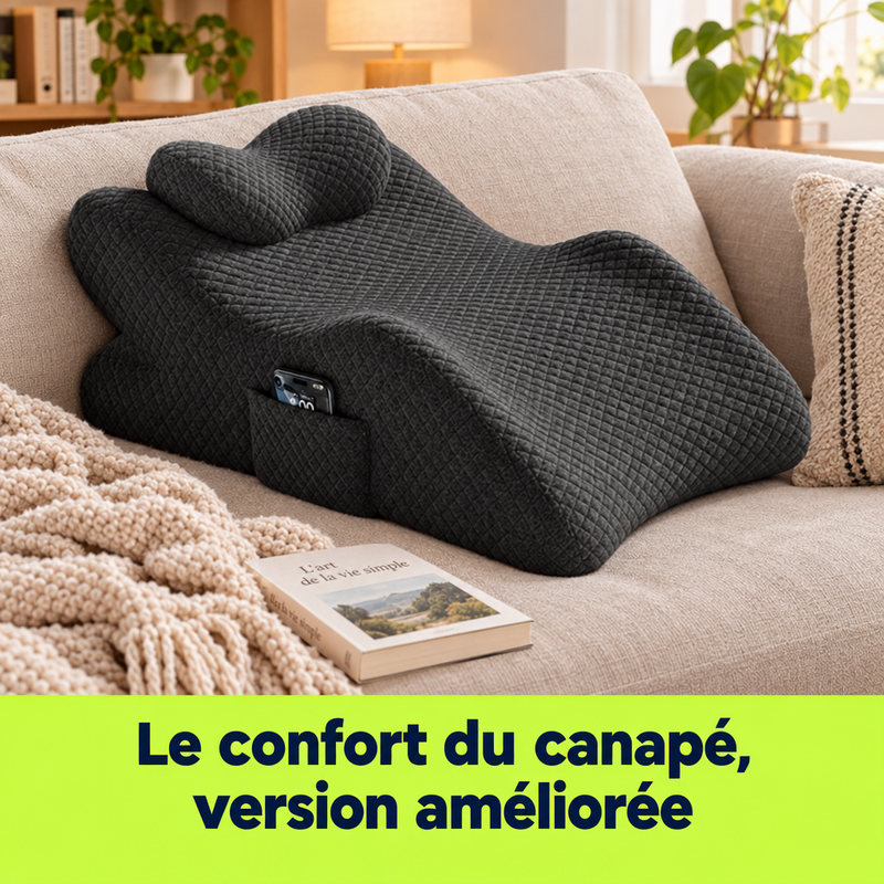 Coussin lombaire LumbaRest sur un canapé avec plaid et livre